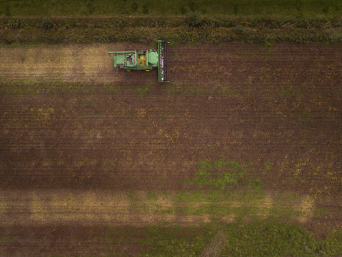 Luchtfot van akker met traktor.
